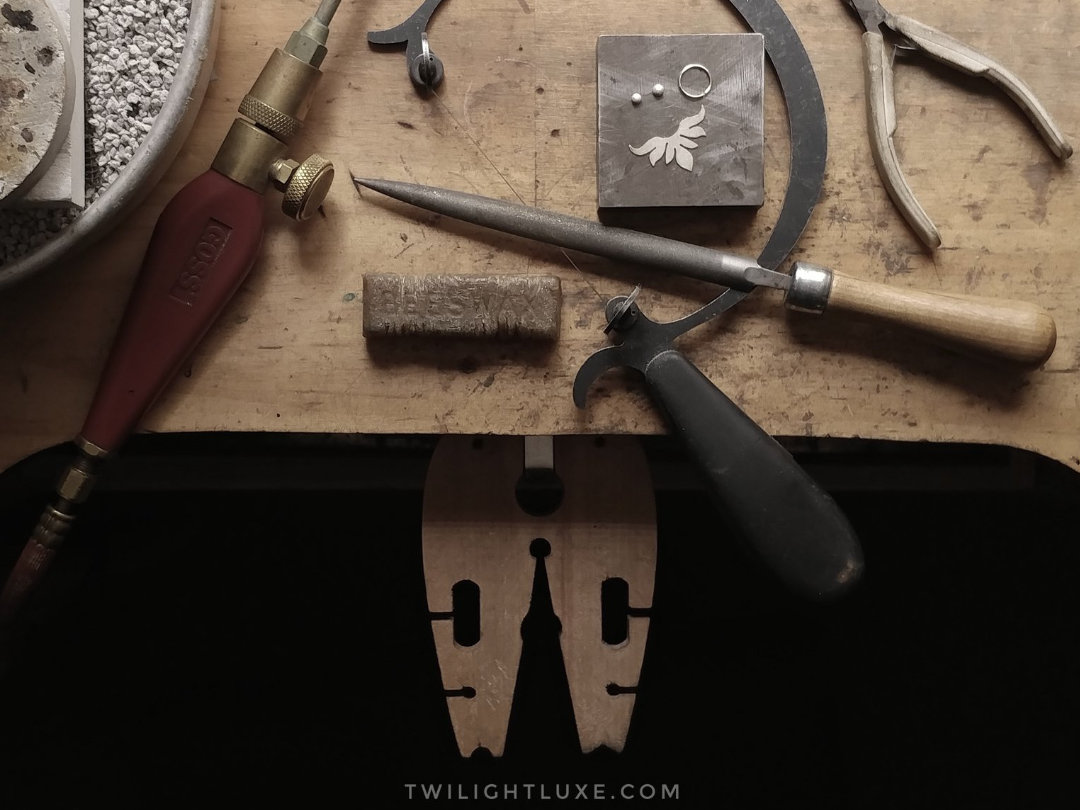 Overhead image of jeweler's bench with assorted hand tools